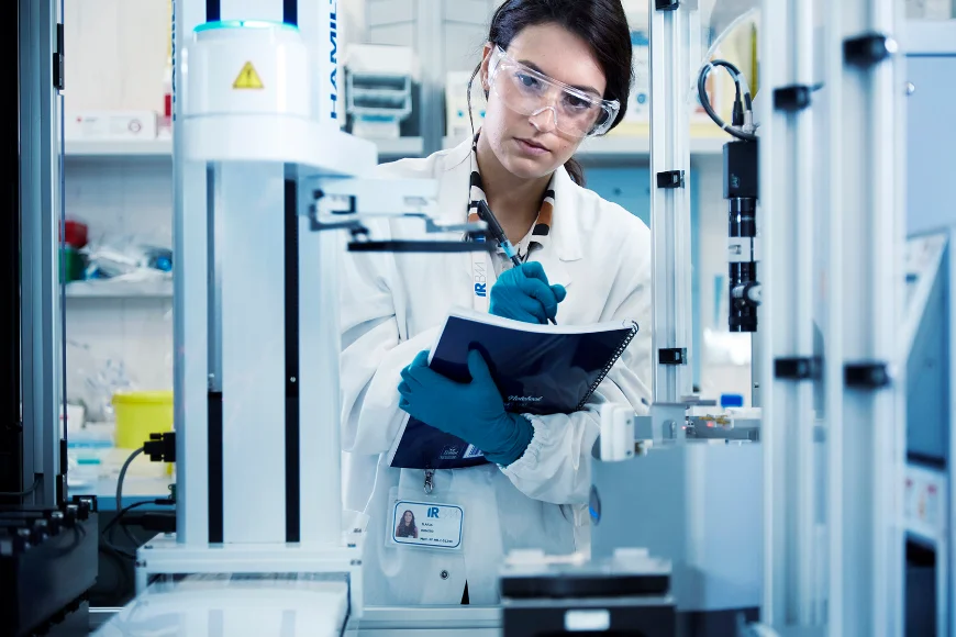 IRBM scientist at an automated liquid handling system
